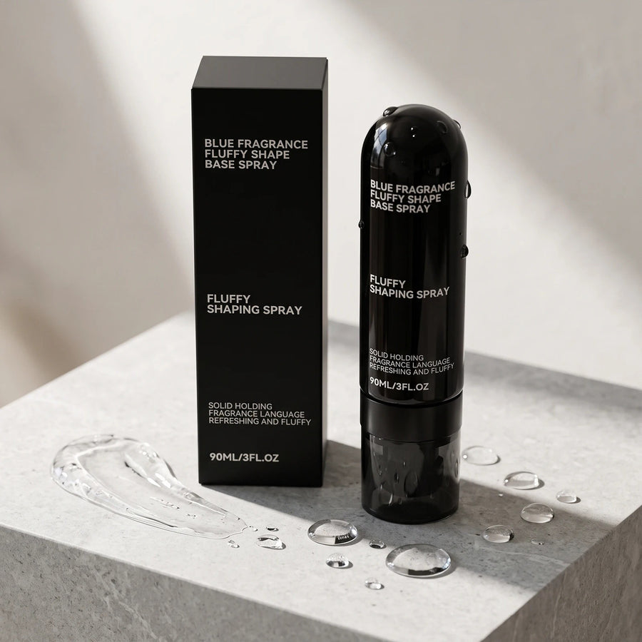 Fluffy Shaping Spray 90 ml i svart flaska bredvid förpackningen på en stenpiedestal