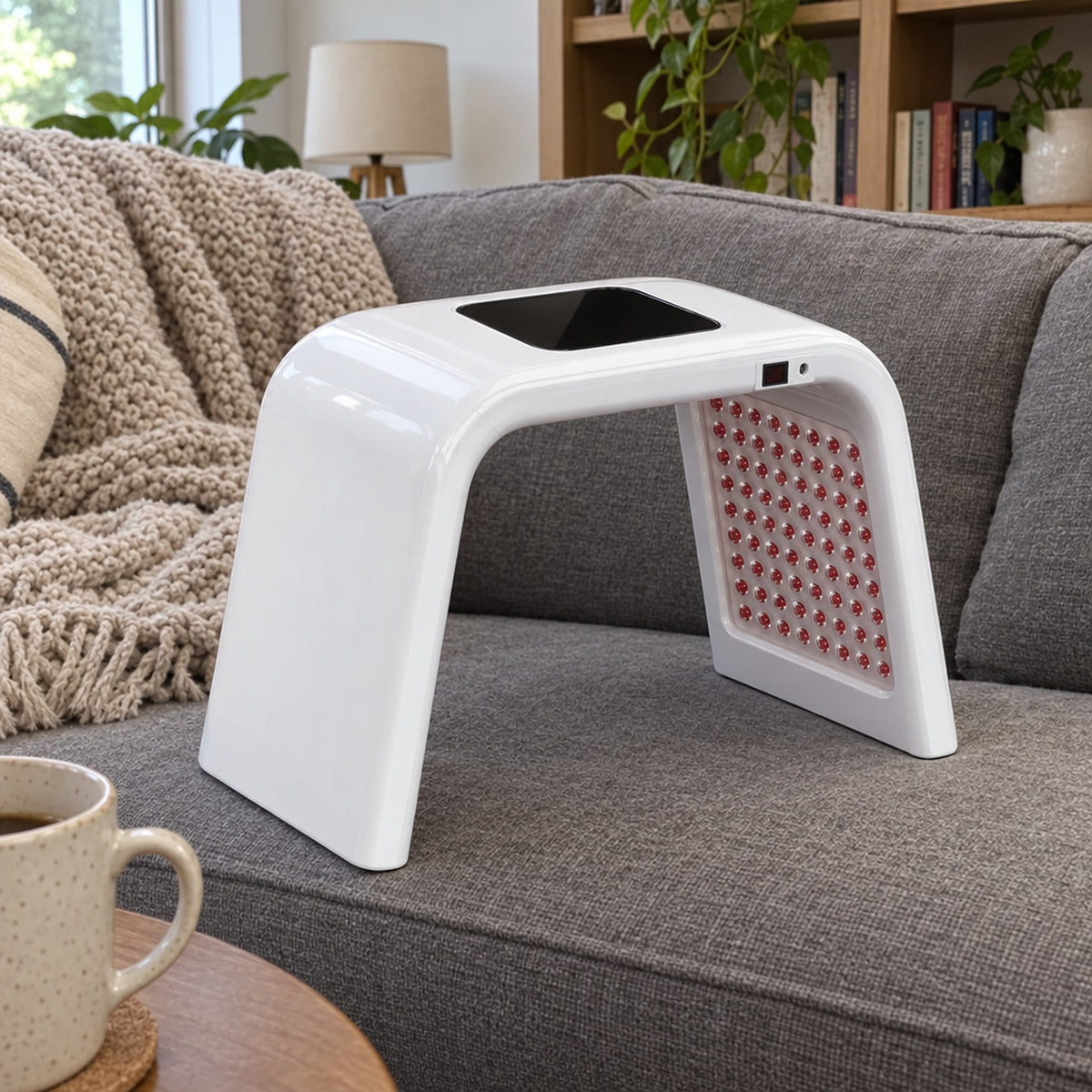 LED-apparat på grå soffa med pläd och kaffekopp