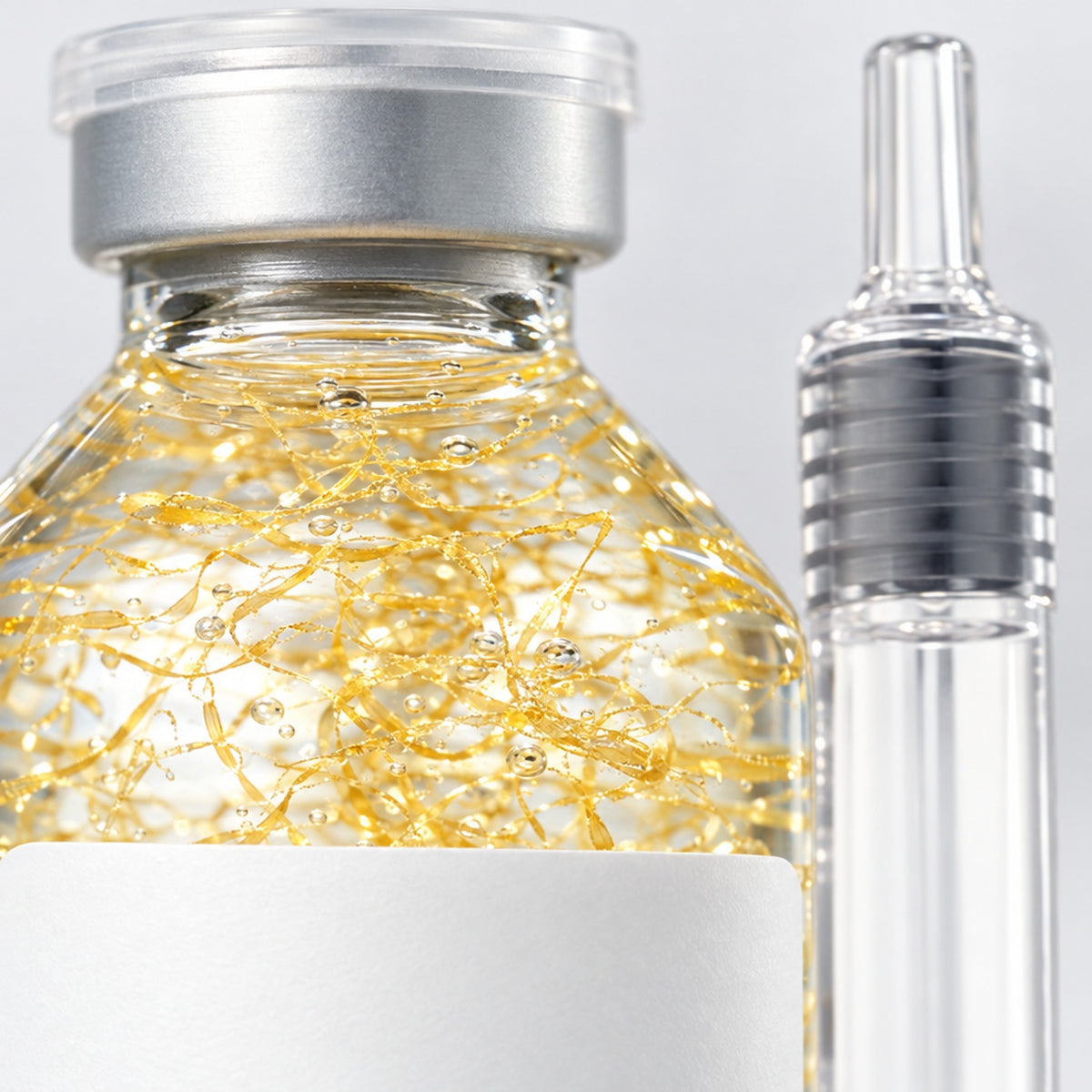 Närbild på gyllene trådar i genomskinligt serum
