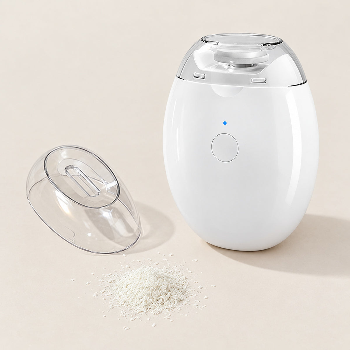 Nagelklippare med avtagen kåpa och nagelspån på beige yta