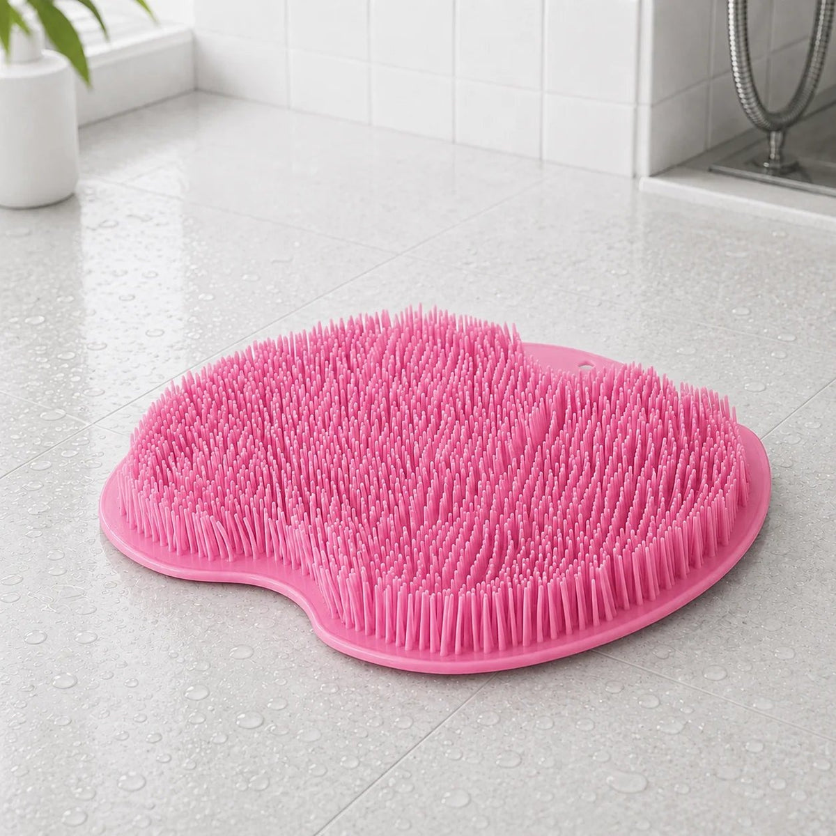 Rosa fotskrubbmatta med mjuka borst på kakelgolv