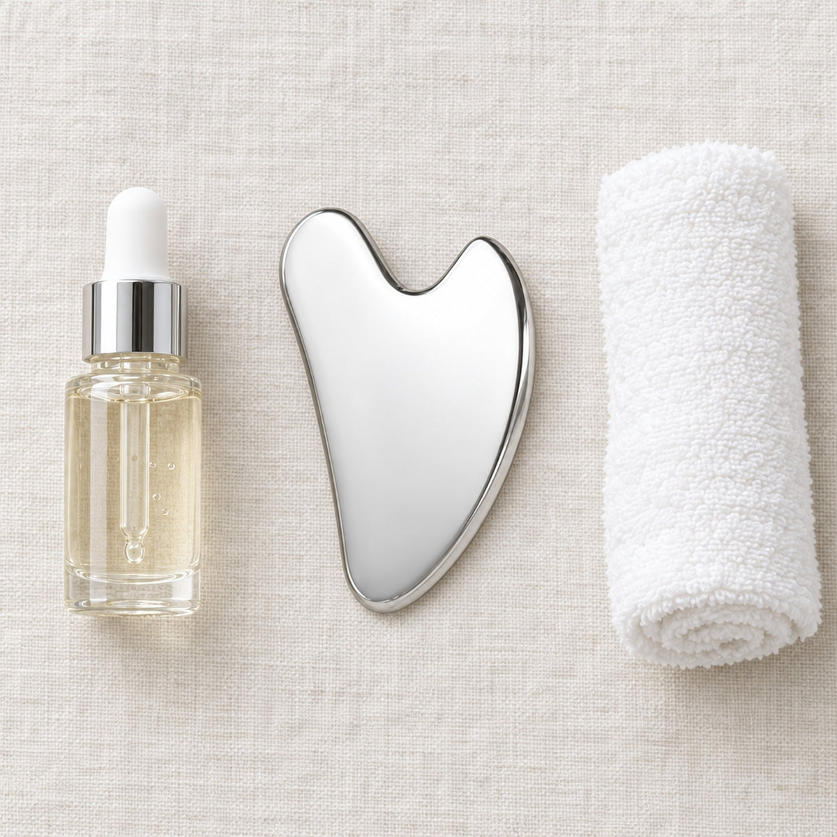 Gua sha, serumflaska och handduk på linnebakgrund
