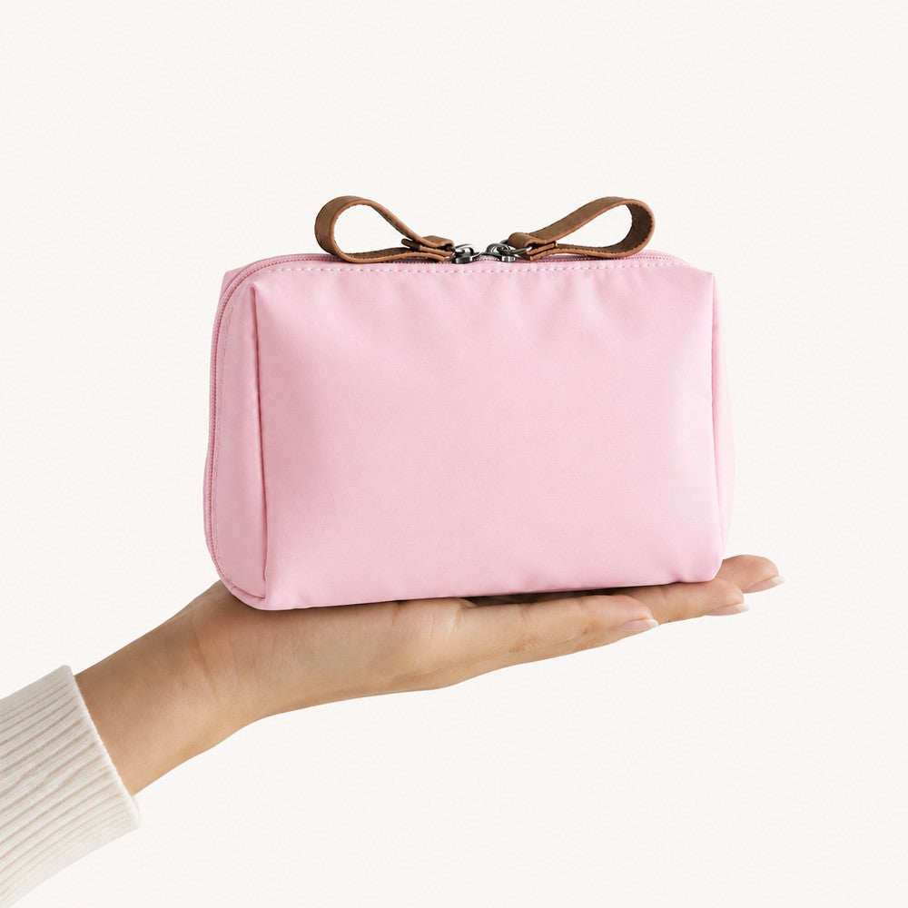 Rosa necessär i nylon hållen i handen